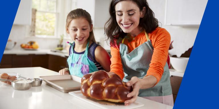 Mother and daughter in kitchen with freshly baked challah.