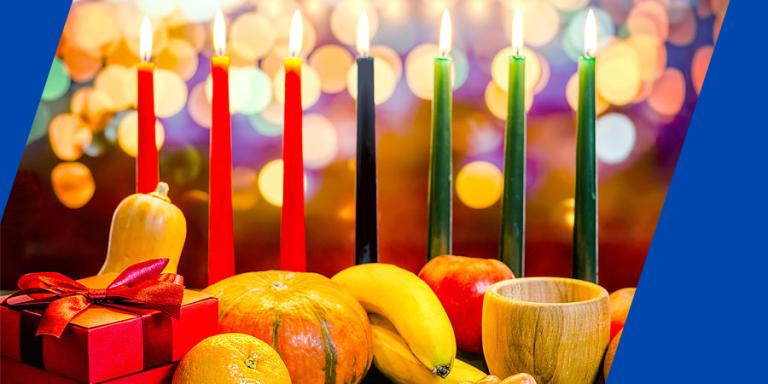 Kwanzaa holiday celebration with seven candles, gift box, and fruit.
