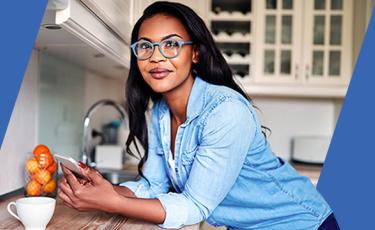 Woman leaning on a counter while using her smartphone