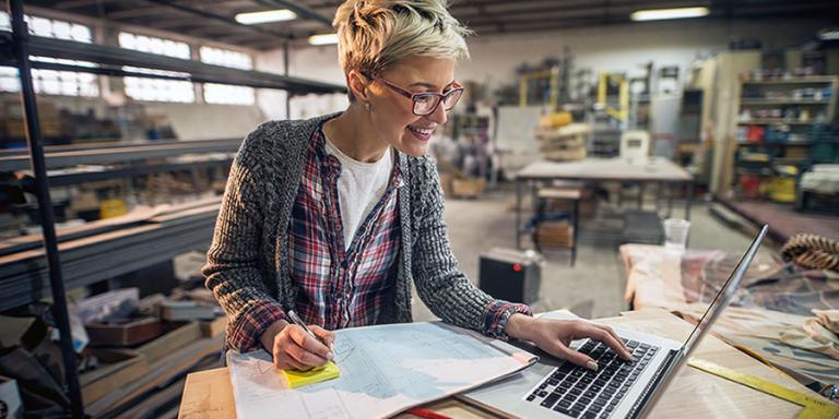 Woman working on her laptop in a shop environment