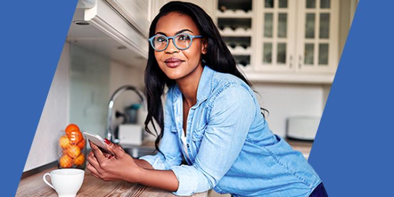 Woman leaning on a counter while using her smartphone