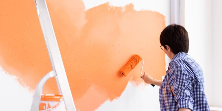 Woman painting a heart on the wall.