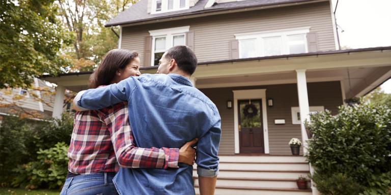 Happy couple in front of the new home.