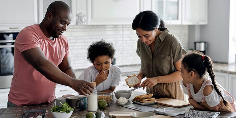 A family is shown cooking dinner in a kitchen