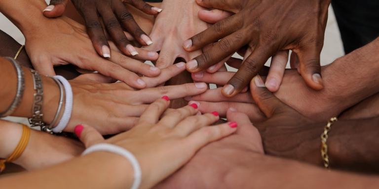 A diversity of hands showing teamwork.