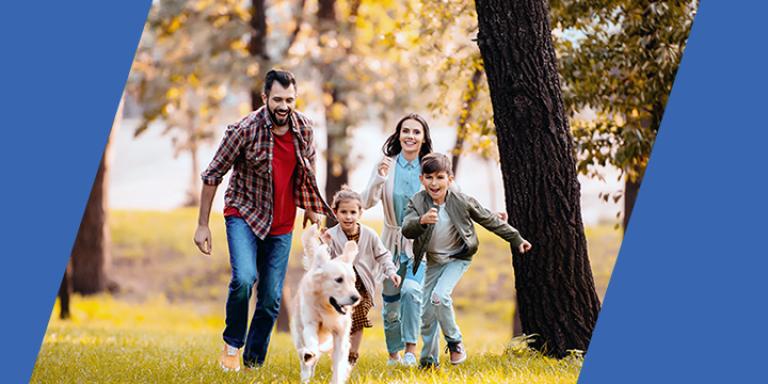 Family and dog running through park