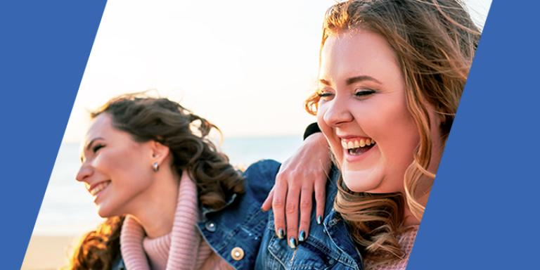 Two woman at the beach laughing