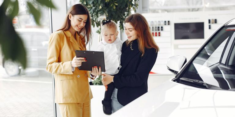 Two women discussing buying a car.
