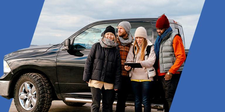 Group of friends standing next to black truck
