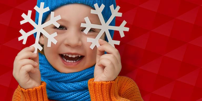 Child holding snowflakes with a red background