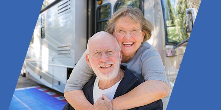 Man and woman hugging in front of RV