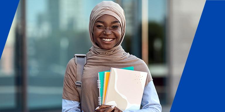 College student in front of education building with folders
