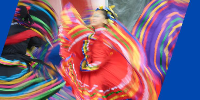 Photo of dancers with colorful dresses swirling in the air.