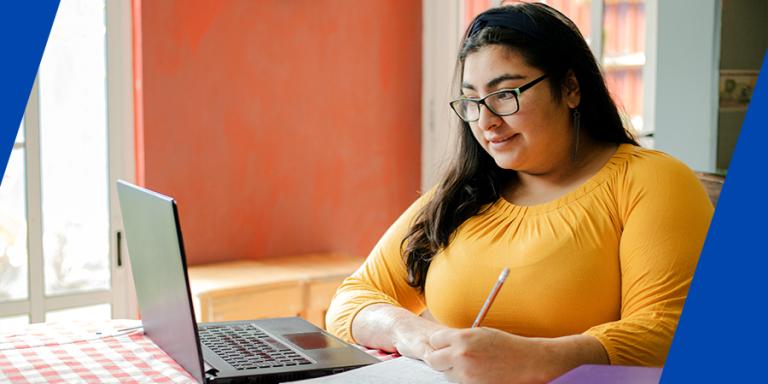 Young hispanic college student studying online.
