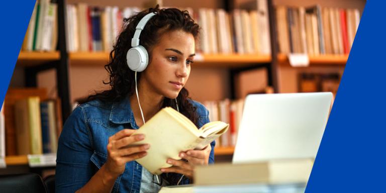 College student with headphones studying in a library.