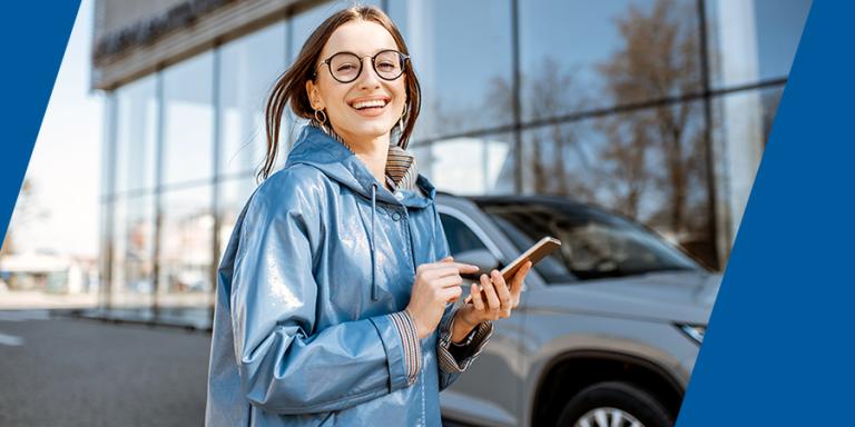 Woman at car dealership with cell phone