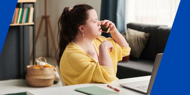 Woman with Down syndrome talking to clients at her home office.