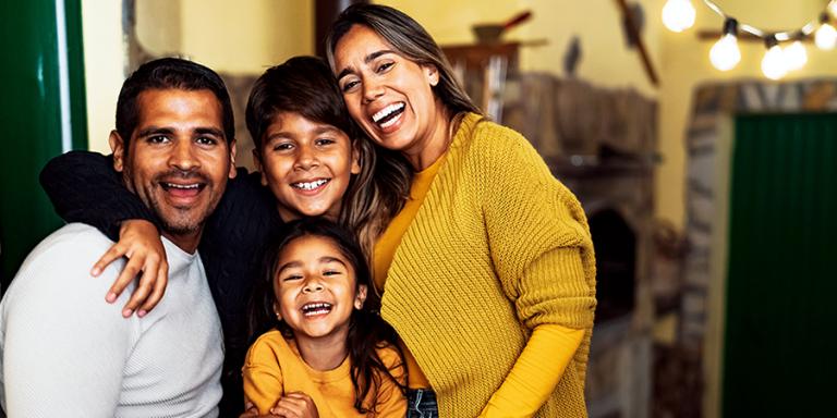 Family posing for a photo in their home