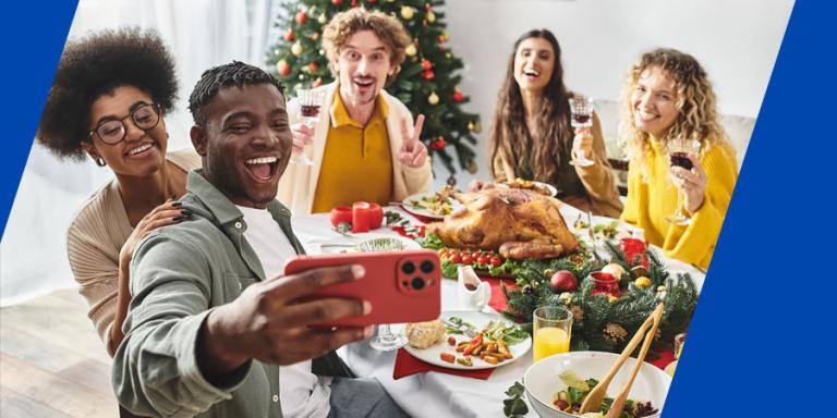 Friend taking a group selfie during a holiday dinner.