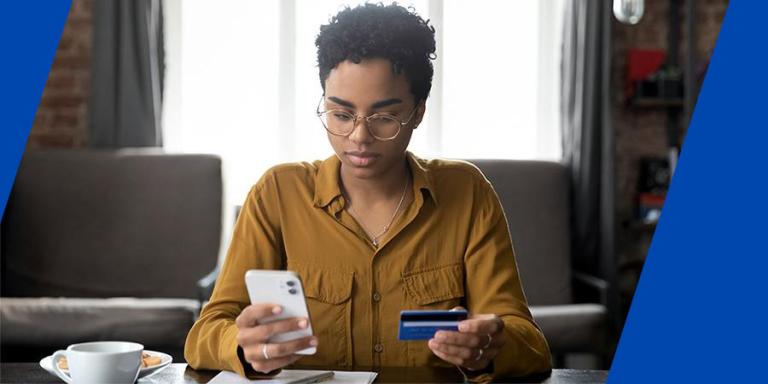 Woman holding gift card and smart phone.