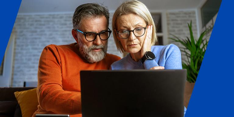 A concerned man and woman looking at a laptop