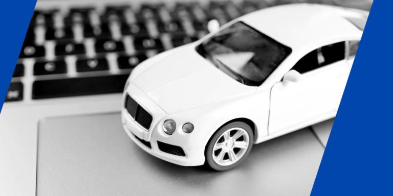 White model toy car on a laptop.