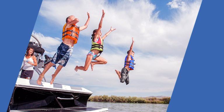 Group of kids jumping off a boat into the water on a sunny summer day.