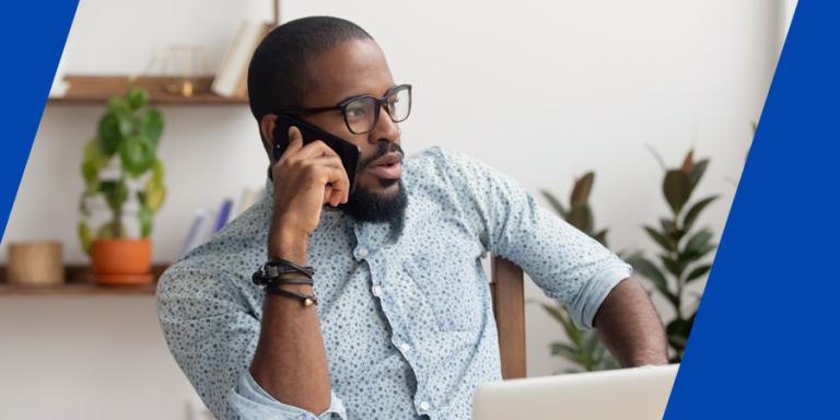 A skeptical person of color receiving an unsolicited phone call asking for personal information.