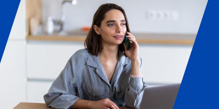 Concerned woman talking on the phone while on a laptop.