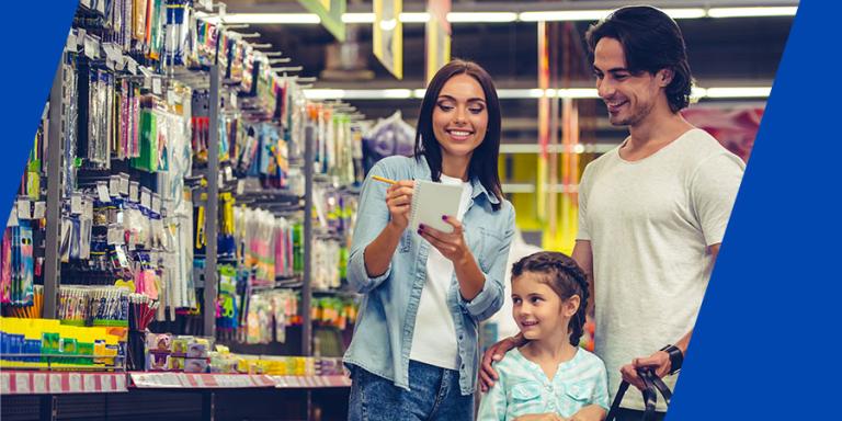 Family shopping for school supplies and checking a list in a store.