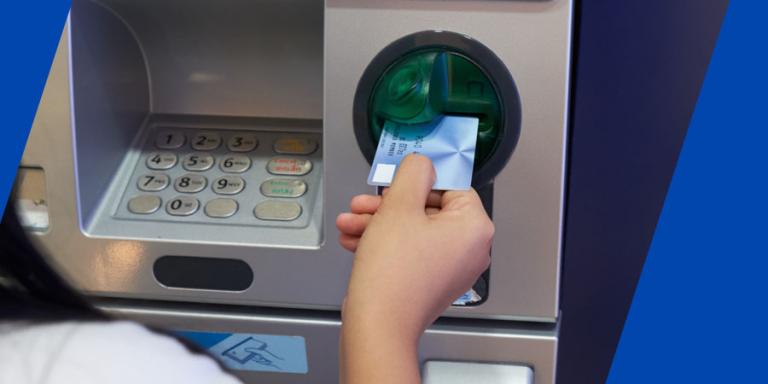 Woman inserting her card into an ATM.