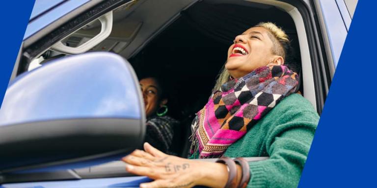 A women driving a car with her elbow out of her window