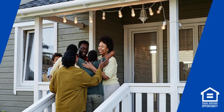 family embracing on the porch of their home