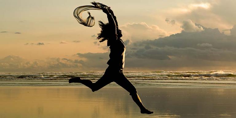 Woman leaping on a beach